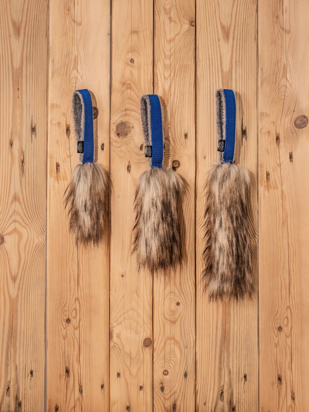 Tres mordedores motivadores de pelo natural con asa azul para juego y entrenamiento canino con descuento.