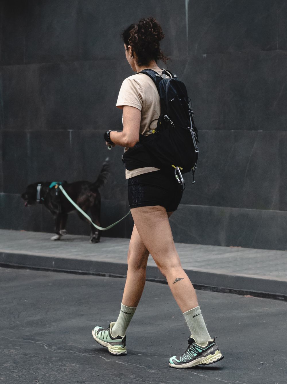 Nei Fuentes, educadora canina de El Perro Negro, paseando por Barcelona con un perro negro con correa larga